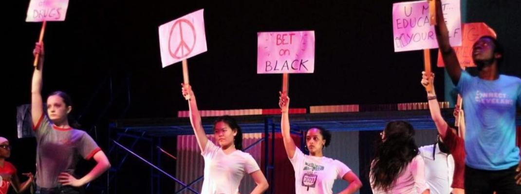 Members of Oberlin's ODC/Dance Company perform with protest signs depicting antiracist slogans